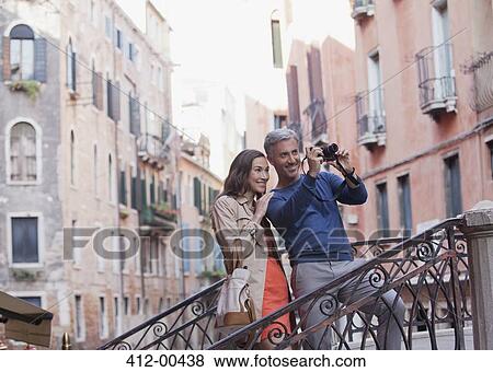 Smiling couple taking photograph in Venice View Large Photo Image Stock Photo - Smiling couple taking photograph in Venice. Fotosearch
