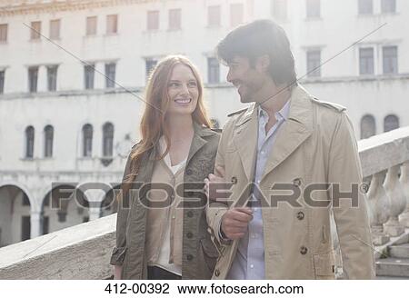Smiling couple walking arm in arm in Venice View Large Photo Image Stock Image - Smiling couple walking arm in arm in Venice. Fotosearch