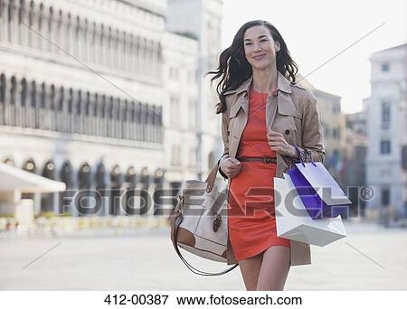 Smiling woman carrying shopping bags through St. Mark's Square n Venic View Large Photo Image Stock Photo - Smiling woman carrying shopping bags through St. Mark's Square n Venic. Fotosearch