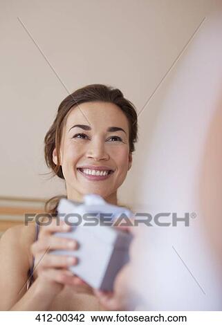 Smiling woman receiving gift from man View Large Photo Image Stock Image - Smiling woman receiving gift from man. Fotosearch