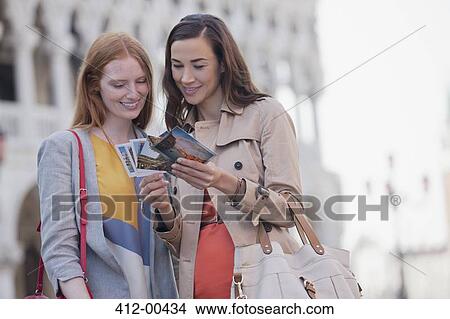 Smiling women looking at postcards View Large Photo Image Picture - Smiling women looking at postcards. Fotosearch
