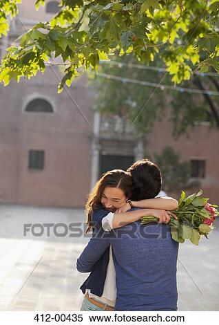 Woman holding flowers and hugging man View Large Photo Image Stock Photography - Woman holding flowers and hugging man. Fotosearch