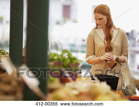 Stock Photography - Woman shopping in outdoor market. Fotosearch