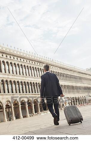 Businessman pulling suitcase through St. Mark's Square in Venice View Large Photo Image Stock Photo - Businessman pulling suitcase through St. Mark's Square in Venice. Fotosearch