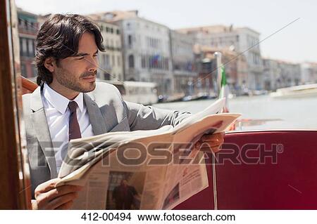 Businessman reading newspaper on boat in Venice View Large Photo Image Picture - Businessman reading newspaper on boat in Venice. Fotosearch