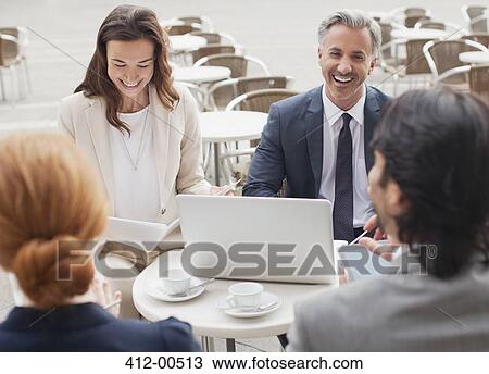 Stock Image - Laughing business people meeting at sidewalk cafe. Fotosearch