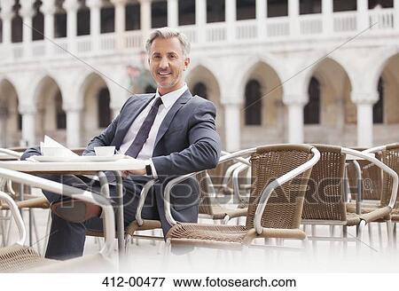 Stock Photo - Portrait of smiling businessman at sidewalk cafe in Venice. Fotosearch