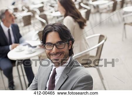 Stock Photography - Portrait of smiling businessman at sidewalk cafe. Fotosearch
