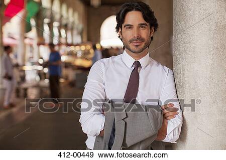 Portrait of smiling businessman leaning on pillar with arms crossed View Large Photo Image Stock Photo - Portrait of smiling businessman leaning on pillar with arms crossed. Fotosearch