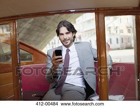 Portrait of smiling businessman with cell phone on boat in Venice View Large Photo Image Picture - Portrait of smiling businessman with cell phone on boat in Venice. Fotosearch
