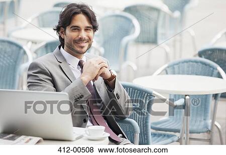 Portrait of smiling businessman with laptop and espresso at sidewalk cafe View Large Photo Image Stock Photo - Portrait of smiling businessman with laptop and espresso at sidewalk cafe. Fotosearch