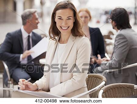 Portrait of smiling businesswoman working at sidewalk cafe View Large Photo Image Stock Photo - Portrait of smiling businesswoman working at sidewalk cafe. Fotosearch