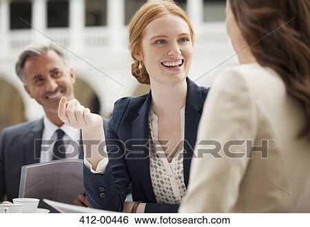 Smiling business people meeting at sidewalk cafe View Large Photo Image Stock Photograph - Smiling business people meeting at sidewalk cafe. Fotosearch