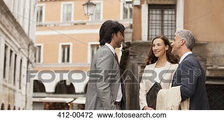 Stock Image - Smiling business people talking. Fotosearch