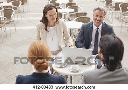 Smiling business people with laptop meeting at sidewalk cafe View Large Photo Image Stock Image - Smiling business people with laptop meeting at sidewalk cafe. Fotosearch