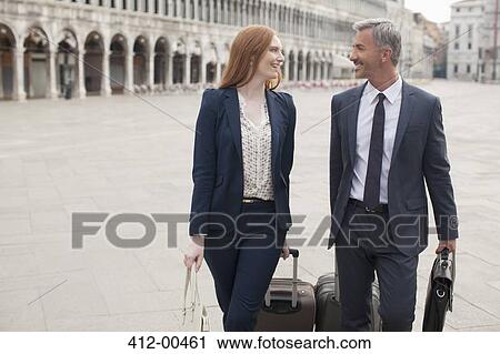 Smiling businessman and businesswoman pulling suitcases through St. Mark's Square in Venic View Large Photo Image Stock Image - Smiling businessman and businesswoman pulling suitcases through St. Mark's Square in Venic. Fotosearch