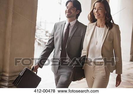 Stock Photo - Smiling businessman and businesswoman walking. Fotosearch