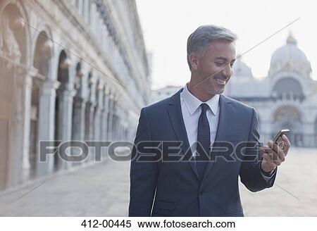 Smiling businessman checking cell phone in St. Mark's Square in Venic View Large Photo Image Stock Photography - Smiling businessman checking cell phone in St. Mark's Square in Venic. Fotosearch