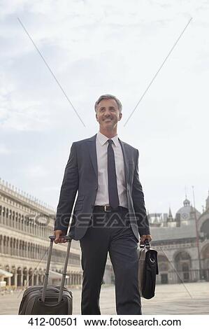 Smiling businessman pulling suitcase through Saint Mark's Square in Venice View Large Photo Image Stock Image - Smiling businessman pulling suitcase through Saint Mark's Square in Venice. Fotosearch