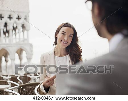 Smiling businesswoman meeting with businessman at sidewalk cafe View Large Photo Image Stock Photo - Smiling businesswoman meeting with businessman at sidewalk cafe. Fotosearch