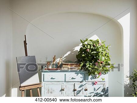 Easel with painting next to bureau with plant and supplies on patio View Large Photo Image Stock Image - Easel with painting next to bureau with plant and supplies on patio. Fotosearch