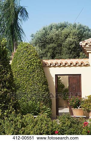 Stock Image - Garden surrounding courtyard doorway of luxury villa. Fotosearch