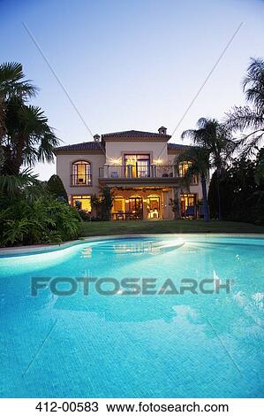 Luxury swimming pool and villa at dusk View Large Photo Image Stock Image - Luxury swimming pool and villa at dusk. Fotosearch