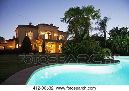 Luxury swimming pool and villa illuminated at night View Large Photo Image Stock Image - Luxury swimming pool and villa illuminated at night. Fotosearch