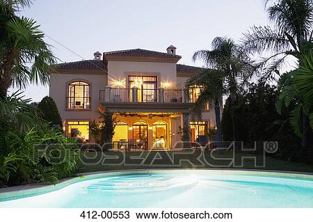 Luxury swimming pool and villa illuminated at night View Large Photo Image Stock Image - Luxury swimming pool and villa illuminated at night. Fotosearch