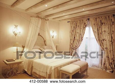Stock Photo - Sconces and canopy above bed in luxury bedroom. Fotosearch