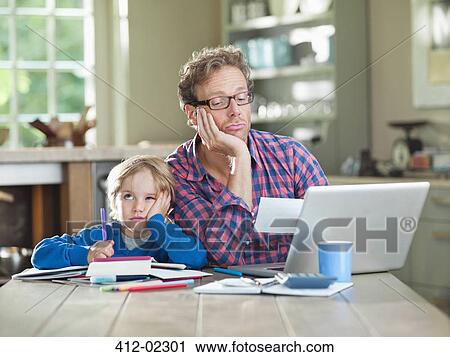 Bored father and son working at table View Large Photo Image Stock Image - Bored father and son working at table. Fotosearch