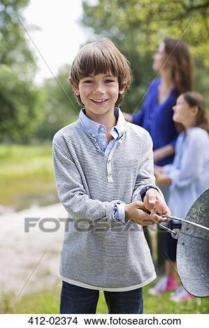Picture - Boy swinging pail outdoors. Fotosearch
