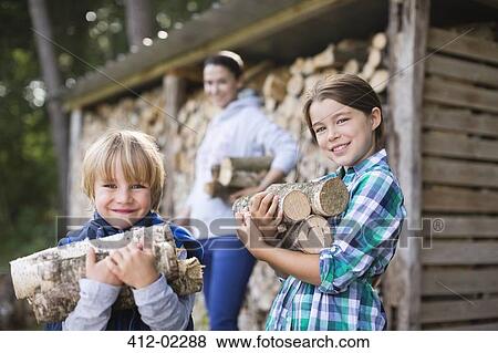 Stock Photo - Children carrying firewood outdoors. Fotosearch