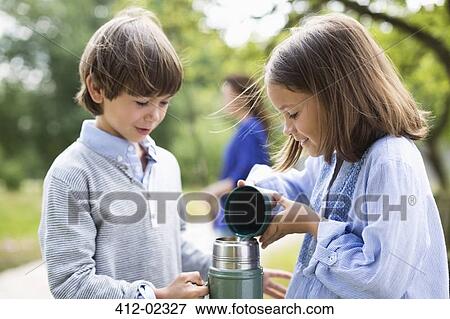 Children pouring tea from thermos outdoors View Large Photo Image Stock Photo - Children pouring tea from thermos outdoors. Fotosearch