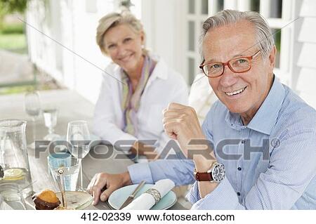 Stock Photo - Couple smiling at table together. Fotosearch