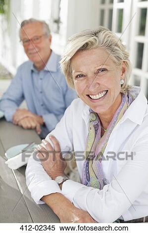 Stock Photography - Couple smiling together at table. Fotosearch
