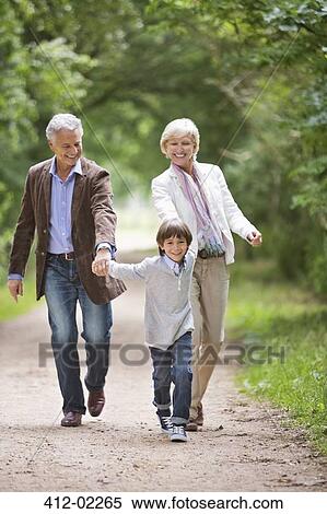 Stock Photography - Couple walking with grandson on rural road. Fotosearch