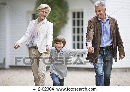 Couple walking with grandson outdoors View Large Photo Image Picture - Couple walking with grandson outdoors. Fotosearch