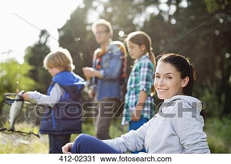 Stock Image - Family fishing together in tall grass. Fotosearch