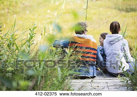 Stock Photography - Family fishing together on wooden dock. Fotosearch