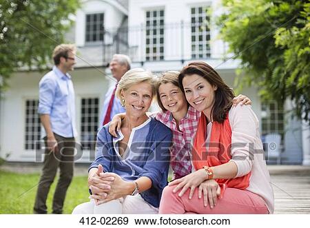 Family smiling together outside house View Large Photo Image Stock Photo - Family smiling together outside house. Fotosearch