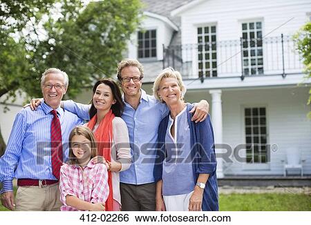 Family smiling together outside house View Large Photo Image Stock Photograph - Family smiling together outside house. Fotosearch