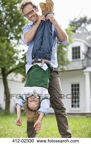 Father and son playing together outdoors View Large Photo Image Stock Image - Father and son playing together outdoors. Fotosearch