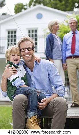 Stock Photo - Father and son smiling outside house. Fotosearch