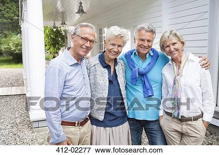 Friends standing together outside house View Large Photo Image Stock Photo - Friends standing together outside house. Fotosearch