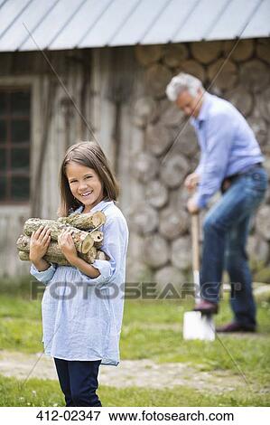 Girl carrying firewood outdoors View Large Photo Image Stock Photo - Girl carrying firewood outdoors. Fotosearch