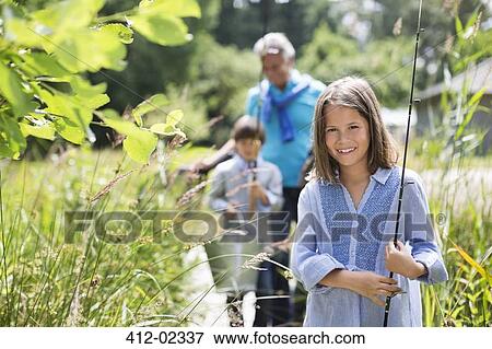 Girl carrying fishing rod in tall grass View Large Photo Image Stock Photo - Girl carrying fishing rod in tall grass. Fotosearch