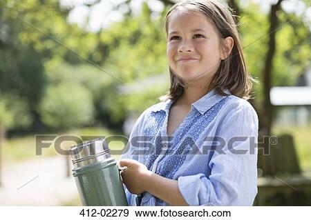 Girl carrying thermos outdoors View Large Photo Image Stock Photo - Girl carrying thermos outdoors. Fotosearch
