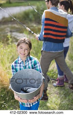 Stock Image - Girl showing off fishing catch. Fotosearch