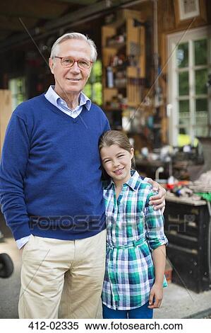 Man and granddaughter smiling in garage View Large Photo Image Stock Photography - Man and granddaughter smiling in garage. Fotosearch